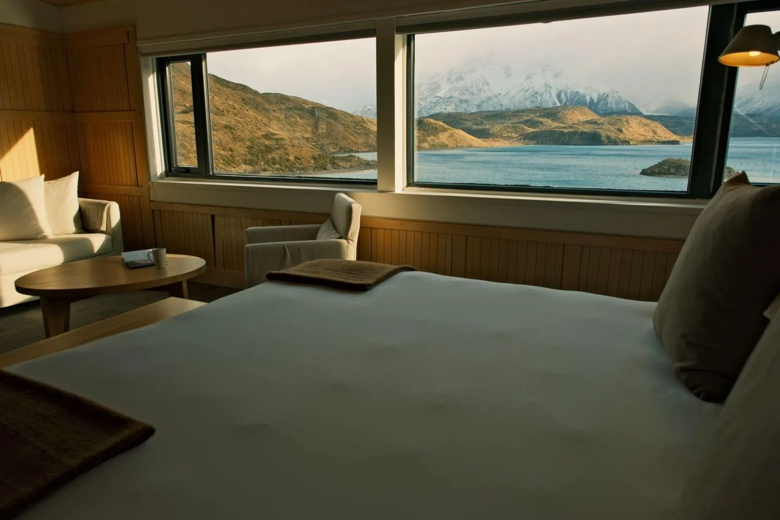 A guest room at Explora Patagonia with wide windows over Lago Pehoé