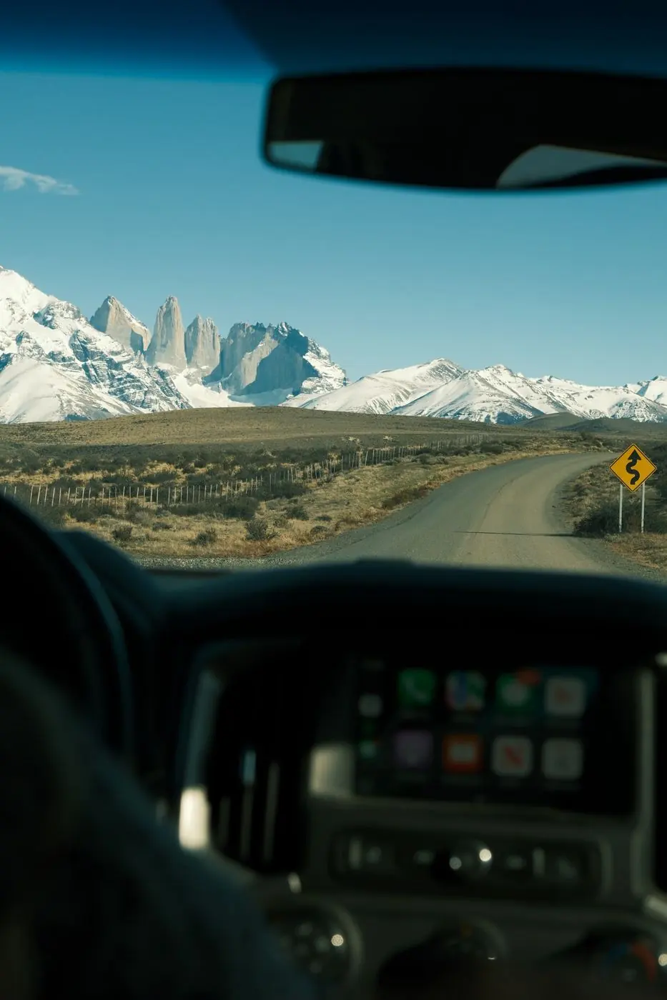 The Paine massif through a car windshield on the gravel road into the park